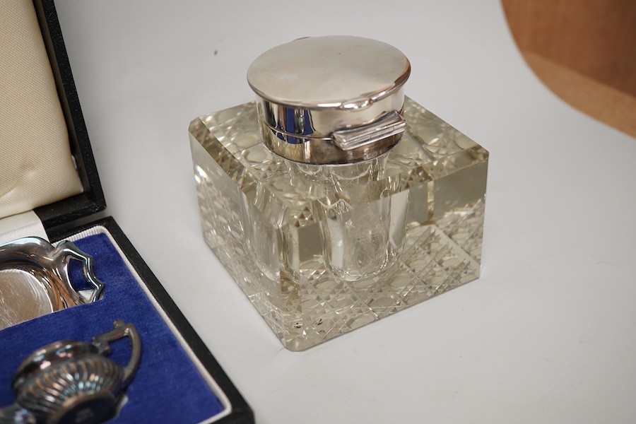 Small silver including a pair of George V pierced silver bonbon dishes, Birmingham, 1915, diameter 97mm, an Edwardian silver mounted glass inkwell, a cased modern silver miniature four piece tea set and tray and a German